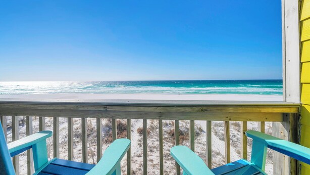 A wooden deck with turquoise chairs overlooking a beach with clear blue water and sandy shore. - Gulf Front- Directly On The Beach- Sunchase 2A (Miramar Beach)