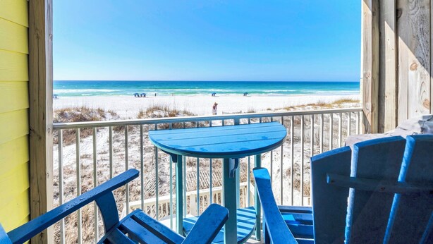 A balcony with a view of the beach, featuring a table and chairs. - Honeymoon Studio* Directly On Sand* Sunchase 3B (Miramar Beach)