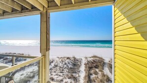 A beach view from a yellow building with a wooden ceiling and a glass window. - Sunchase 7A - Directly On The Beach! Sleeps 8-Walk to Restaurants, AMAZING VIEWS! (Miramar Beach)