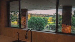 Una cocina con un lavamanos moderno y un amplio ventanal con vistas a un paisaje verde.