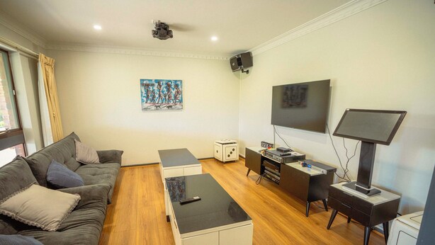 Un salon moderne comprenant un canapé, une table basse, un téléviseur et un petit bureau avec un ordinateur.