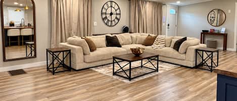 A living room with a sectional sofa, a coffee table, and a ceiling fan.
