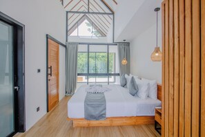 Quarto com uma cama grande, cabeceira de madeira e claraboia.