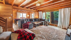 A cozy log cabin interior with a pool table, a sofa, and a large window offering a view of the outdoors. - Idyllwild Retreat - Fire Pit, Views, Game Room (Idyllwild-Pine Cove)