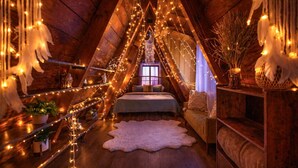 A cozy attic bedroom with a bed, a white fur rug, and string lights. - Idyllwild Retreat - Fire Pit, Views, Game Room (Idyllwild-Pine Cove)