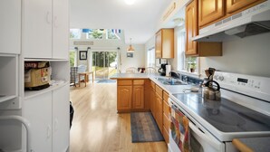 Una cocina moderna con armarios de madera, una estufa grande y un comedor con vistas.