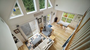 Una habitación amplia con un gran ventanal, una zona de estar acogedora con sofá y mesa, y vistas al exterior.