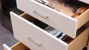 Una cocina con horno integrado, encimera de madera y mueble con varios compartimentos.
