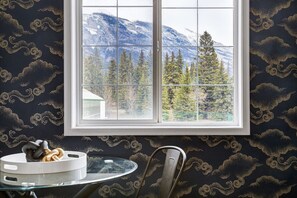 A room with a large window, a round table with a white tray, and a chair. - The Perfect Getaway for Exploring Canmore &Banff (Canmore)