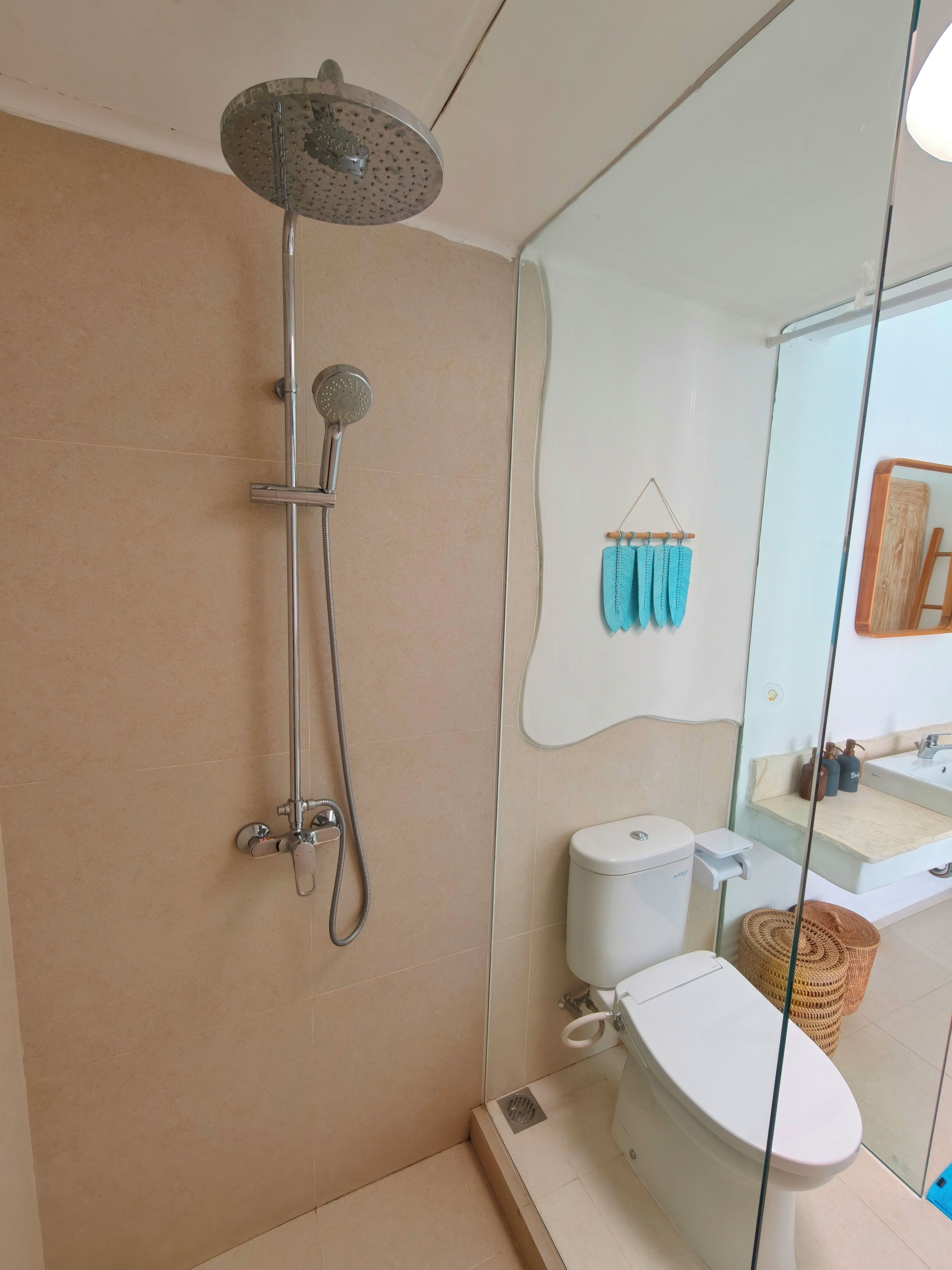 A modern bathroom with a shower, toilet, and sink.