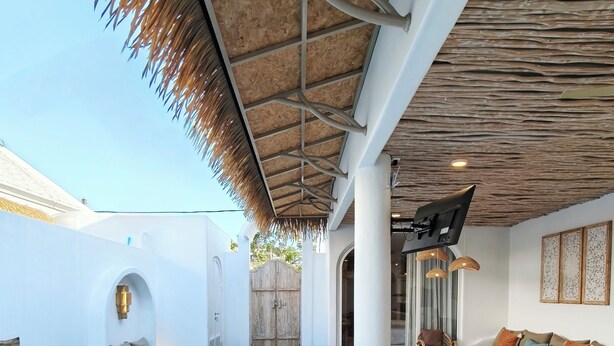 A pool area with a covered seating area, a sofa, and a dining table. - Villa Chioni Uluwatu (Ungasan)