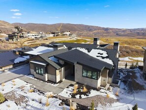 Ein modernes Haus mit Satteldach, Garage und Auffahrt.