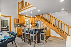 A modern kitchen with wooden cabinets, a bar area, and a staircase. - Abode at Crestview, private hot tub, minutes to Deer Valley (Park City)