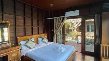 A spacious bedroom with a large bed, wooden headboard, and a nightstand.