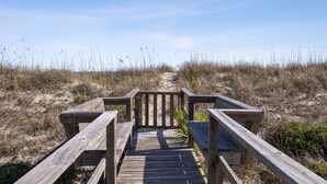 A wooden boardwalk leading to a beach with sand dunes and sparse vegetation. - Oceanfront Pet-Friendly Retreat w/ Private Courtyard (Fernandina Beach)