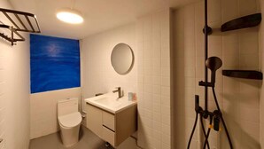 A compact bathroom with a toilet, sink, mirror, and shower. -  Anlan Residence Hotel Cultural Road Pavilion in Jietu, Orange Wood Hidden Garden (Chiayi City)
