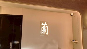 A room with a black door, a wall-mounted security camera, and a small shelf with items. -  Anlan Residence Hotel Cultural Road Pavilion in Jietu, Orange Wood Hidden Garden (Chiayi City)