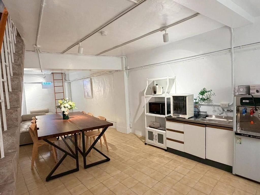 Una cocina moderna con armarios blancos, una mesa de comedor de madera y un microondas integrado.