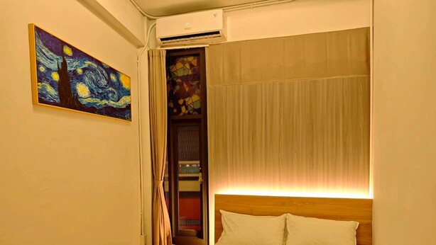 A bedroom with a bed, a painting, a door, and an air conditioning unit. -  Anlan Residence Hotel Cultural Road Pavilion in Jietu, Orange Wood Hidden Garden (Chiayi City)