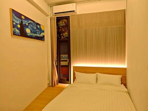 A bedroom with a bed, a painting, a door, and an air conditioning unit. -  Anlan Residence Hotel Cultural Road Pavilion in Jietu, Orange Wood Hidden Garden (Chiayi City)