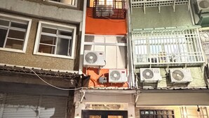 A multi-story building with air conditioning units, a closed shop, and parked motorcycles. -  Anlan Residence Hotel Cultural Road Pavilion in Jietu, Orange Wood Hidden Garden (Chiayi City)