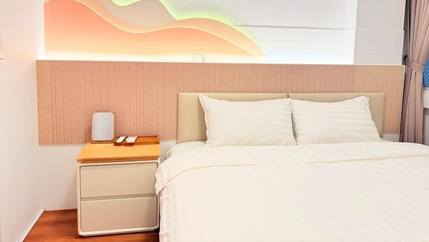 A bedroom with a bed, nightstand, and wall-mounted light fixture. -  Anlan Residence Hotel Cultural Road Pavilion in Jietu, Orange Wood Hidden Garden (Chiayi City)