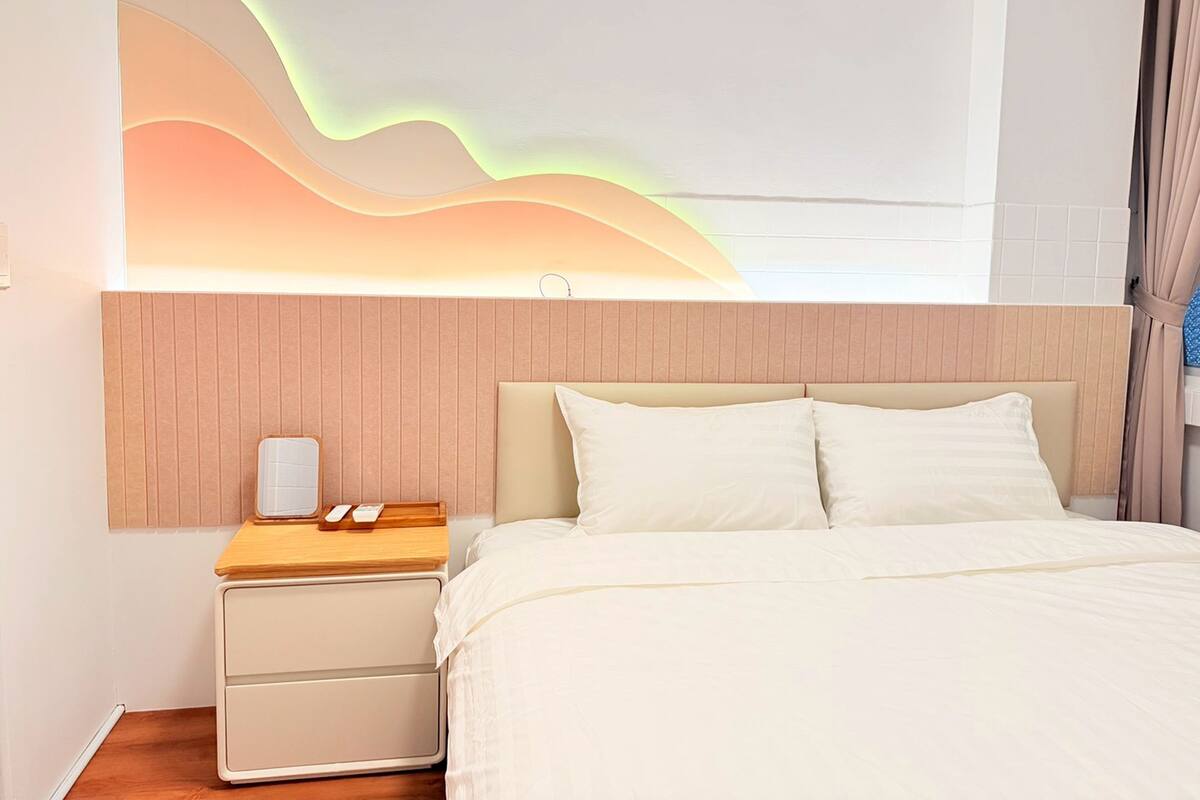 Ein Schlafzimmer mit Bett, Nachttisch und Wandleuchte.