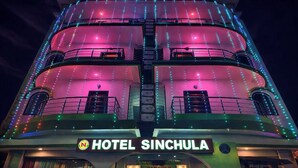 Ein mehrstöckiges Hotel mit Balkonen und einem Schild mit der Aufschrift 'HOTEL SINCHULA'.