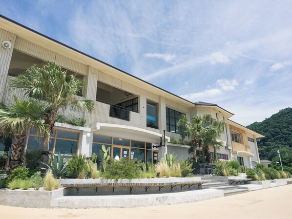 A modern hotel with a two-story structure, large windows, and a balcony area. - Good Fellows Resort (Kagoshima)