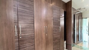 Een moderne kast met horizontale houtnervuur, metalen handgrepen en een glazen deur.