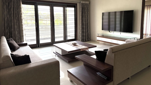 A modern living room with a sofa, coffee table, TV, and sliding glass doors.