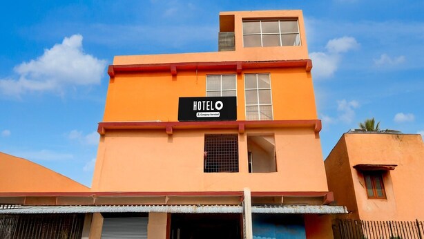 Un hôtel à plusieurs étages, avec une enseigne indiquant qu’il est géré par une entreprise.