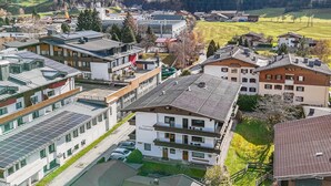 Un hôtel moderne doté d’un toit plat, de panneaux solaires et offrant une vue sur les montagnes et les champs environnants.