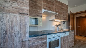 Une cuisine moderne avec des meubles en bois, un four encastré et un four à micro-ondes.