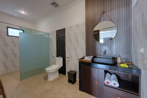 A modern bathroom with a toilet, sink, and mirror. - Kelingking Mesari Villa & Spa (Penida Island)