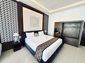 A modern bedroom with a large bed, a dark wooden headboard, a decorative wall panel, and a built-in wardrobe. - Kelingking Mesari Villa & Spa (Penida Island)
