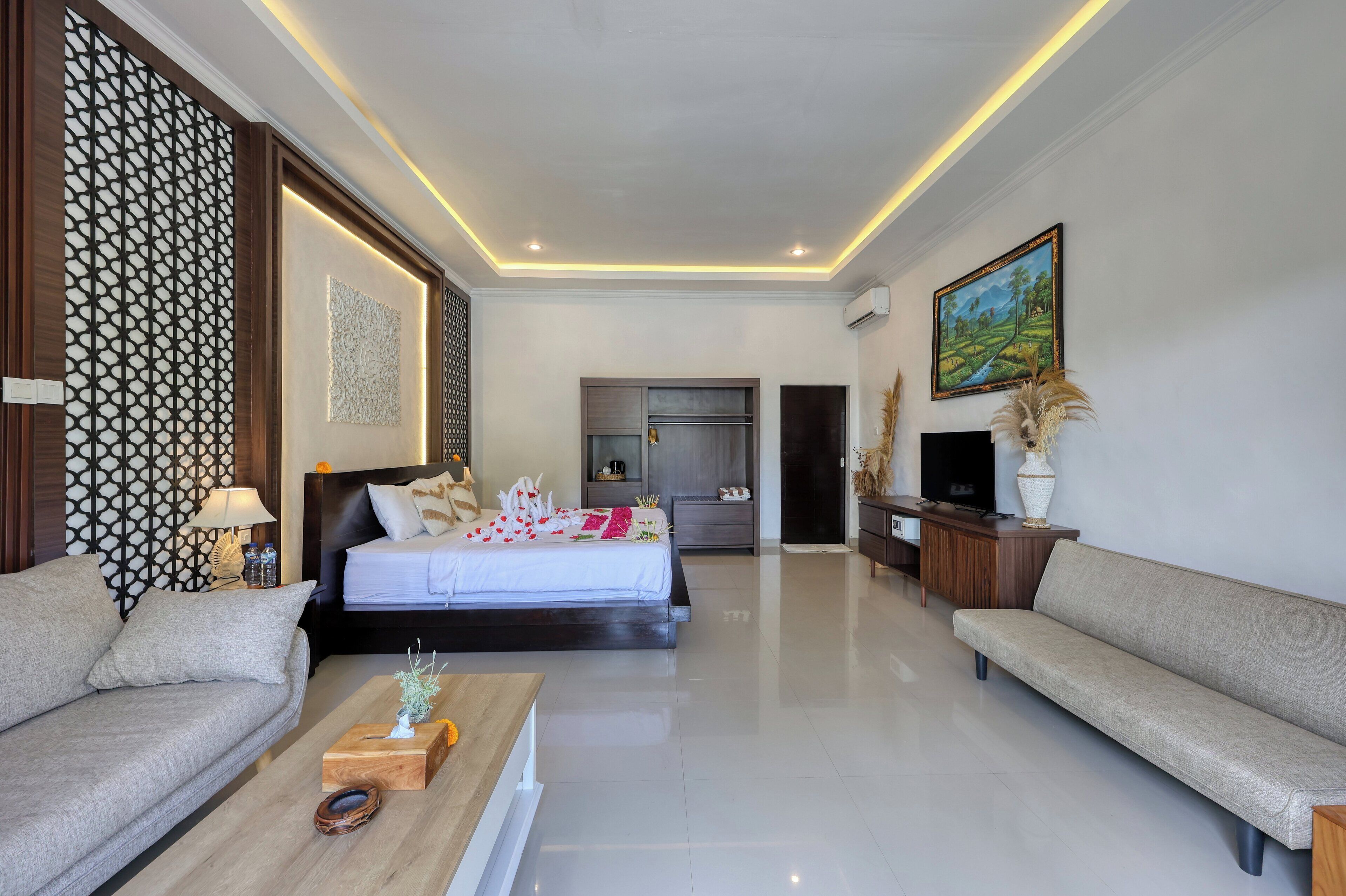 Una habitación de hotel moderna con cama, sofá y televisión.