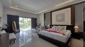 A modern bedroom with a large bed, a desk, a chair, and a view of the outdoors. - Kelingking Mesari Villa & Spa (Penida Island)