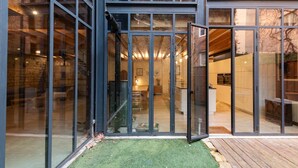 A modern building with large glass doors leading to a well-lit interior.