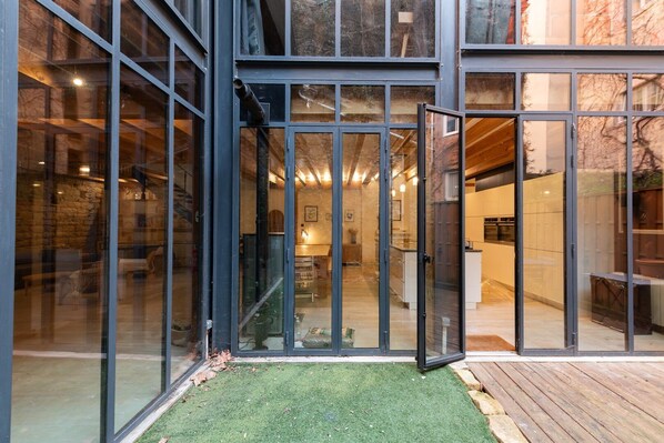A modern building with large glass doors leading to a well-lit interior.