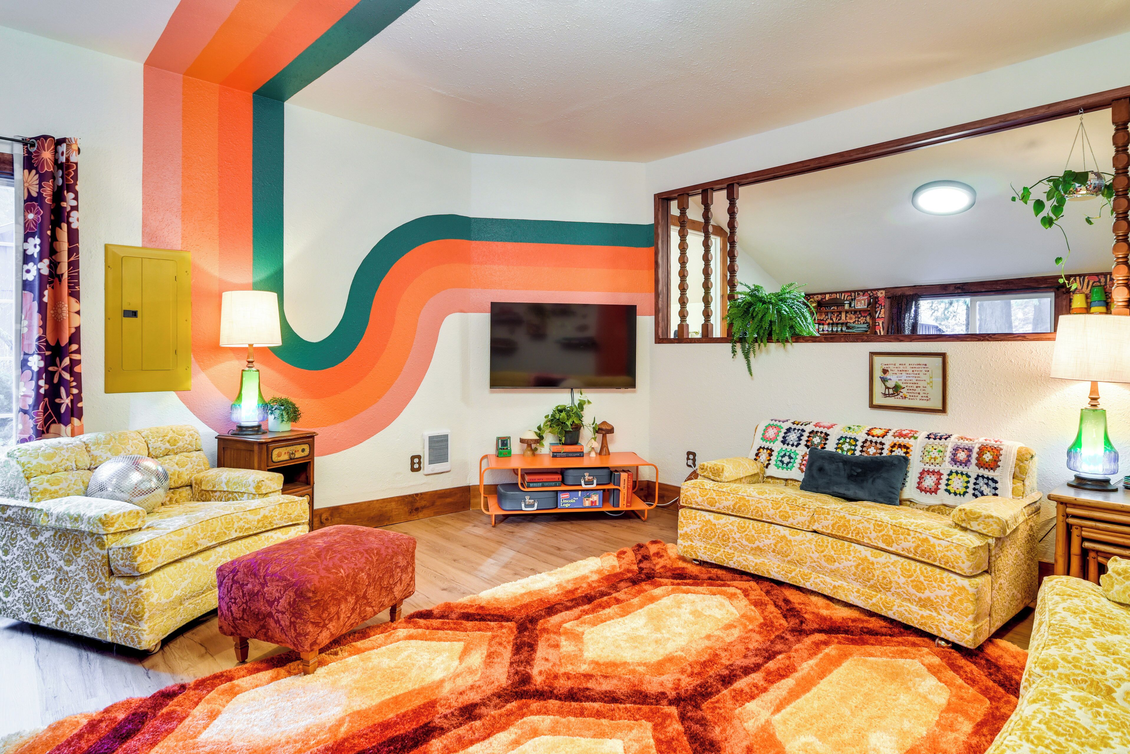 A retro-styled living room with two sofas, a coffee table, and a large mirror.