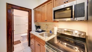 A kitchen with wooden cabinets, a stainless steel microwave, an oven, and a sink. - Epic Silver Valley Basecamp: Steps to Dtwn Fun! (Wallace)