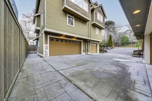 Une maison à deux étages avec un garage et une allée couverte.