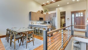 A modern kitchen with wooden cabinets, stainless steel appliances, and a glass dining table with chairs. - Luxe Eden Gem w/ Hot Tub: 6 Mi to Powder Mountain! (Eden)