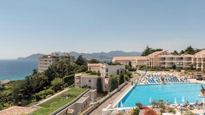 A hotel with a swimming pool, multiple balconies, and a view of the sea. - Cannes Villa Francia - Maeva Home (Cannes)
