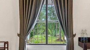 A room with a window, a wooden bench, and a small table with bottles. - The Tusker's Hideout (Alawwa)