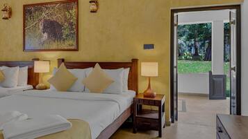 A hotel room with a large bed, two bedside tables with lamps, a painting of a leopard, and a door leading to an outdoor area.