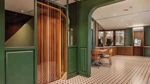 A modern interior with a staircase, a dining area with chairs, and a check-in counter. - LUXIAINN (Tainan)
