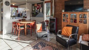 Ein Wohnzimmer mit Fernseher, Kamin und Essbereich mit Stühlen und Tisch.
