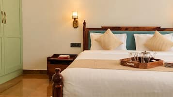 Una habitación de hotel con cama, mesita de noche y lámpara de pared.